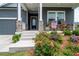 Inviting front porch with stone pillars, rocking chairs, and vibrant landscaping at 3026 Towne Mill Ave, Canton, GA 30114