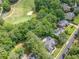 Aerial view of a house with a pool that backs up to a golf course surrounded by trees at 407 Amber Ln, Woodstock, GA 30189