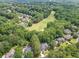 Aerial view of a residential neighborhood situated near a golf course surrounded by lush trees at 407 Amber Ln, Woodstock, GA 30189