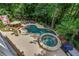Aerial view showcases a stunning pool, spa, lush landscaping, and wooded backyard at 407 Amber Ln, Woodstock, GA 30189