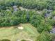 Aerial view of a golf course with houses surrounded by mature trees and lush greenery at 407 Amber Ln, Woodstock, GA 30189