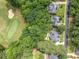 Aerial view of houses and a golf course with mature trees and lush greenery at 407 Amber Ln, Woodstock, GA 30189
