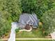 Aerial view of a beautiful landscaped home featuring mature trees, green grass, and a long driveway at 407 Amber Ln, Woodstock, GA 30189