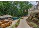 A beautiful pool and spa and lounge area with a wooded view make this an oasis at 407 Amber Ln, Woodstock, GA 30189