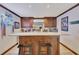 Home bar with wooden cabinets, countertop space, seating, and decorative lighting at 407 Amber Ln, Woodstock, GA 30189