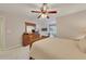 Comfortable bedroom featuring neutral walls, carpeted floor, ceiling fan, and a classic wooden dresser at 407 Amber Ln, Woodstock, GA 30189