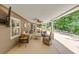 Covered patio with comfortable seating, ceiling fan, and a wooded backyard view at 407 Amber Ln, Woodstock, GA 30189