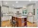 Well-lit kitchen features white cabinets, black countertops, island, and stainless appliances at 407 Amber Ln, Woodstock, GA 30189