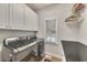 Laundry room with gray washer and dryer and white cabinets at 407 Amber Ln, Woodstock, GA 30189