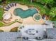 Aerial view of a beautiful kidney-shaped pool, spa, and lounging area, surrounded by lush landscaping and a spacious deck at 407 Amber Ln, Woodstock, GA 30189