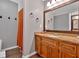 Well-lit bathroom featuring a granite vanity, a large framed mirror, and a walk-in shower with an orange curtain at 6918 Heritage Pl, Acworth, GA 30102