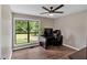 Bedroom with hardwood floor, ceiling fan, and large window with view of front yard at 6918 Heritage Pl, Acworth, GA 30102
