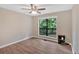Bedroom featuring hardwood floors, ceiling fan, and a large window with views of the backyard at 6918 Heritage Pl, Acworth, GA 30102