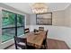Bright dining room features a wooden table, neutral walls with wainscoting and views of backyard through windows at 6918 Heritage Pl, Acworth, GA 30102