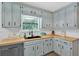 Charming kitchen features butcher block counters, light blue cabinets, black hardware and stainless steel appliances at 6918 Heritage Pl, Acworth, GA 30102
