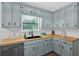 Charming kitchen features blue cabinets, wood countertops, stainless steel appliances, and a bright window view at 6918 Heritage Pl, Acworth, GA 30102