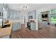 Open kitchen featuring blue cabinets, butcher block counters, stainless appliances, and seamless flow to living room at 6918 Heritage Pl, Acworth, GA 30102