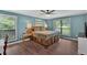 Spacious main bedroom with natural light, hardwood floors, ceiling fan, and a decorative bedframe at 6918 Heritage Pl, Acworth, GA 30102