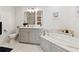Bright bathroom with a marble floor, soaking tub, and grey vanity with white countertop at 77 Peachtree Ne Pl # 101, Atlanta, GA 30309
