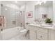 Bright bathroom featuring a shower-over-tub, white tile, and a white vanity with marble countertop at 77 Peachtree Ne Pl # 101, Atlanta, GA 30309