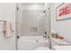 Bright bathroom featuring a shower-over-tub with glass doors, white tile, and fresh towels at 77 Peachtree Ne Pl # 101, Atlanta, GA 30309
