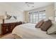Bright bedroom featuring a ceiling fan, wooden dresser, shutters and a large bed at 77 Peachtree Ne Pl # 101, Atlanta, GA 30309