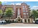 Brick condo building featuring multiple stories, balconies, manicured landscaping, and a covered entry at 77 Peachtree Ne Pl # 101, Atlanta, GA 30309