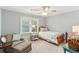 Cozy bedroom with a ceiling fan, natural light, and a comfortable seating area at 100 Spring Ridge Ct, Roswell, GA 30076
