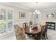 Dining room with elegant chandelier, wainscoting, and natural light from shuttered windows at 100 Spring Ridge Ct, Roswell, GA 30076