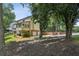 Backyard with brick-laid driveway, mature trees, and a peek at the back of the home at 100 Spring Ridge Ct, Roswell, GA 30076