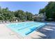 Community pool, surrounded by trees and lounge chairs, perfect for summer relaxation and recreation at 100 Spring Ridge Ct, Roswell, GA 30076
