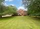 Traditional two-story brick home surrounded by mature trees and a spacious front yard at 110 Wyngate Way, Fayetteville, GA 30215