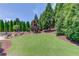 Expansive backyard with lush green lawn, mature trees, and patio area perfect for outdoor living at 120 Slate Dr, Buford, GA 30518