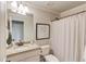 Bright bathroom with a granite countertop vanity and a shower-tub combination behind a white curtain at 120 Slate Dr, Buford, GA 30518