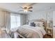 Well-decorated bedroom with a large bed, a ceiling fan, hardwood floors, and a sitting area by the window at 120 Slate Dr, Buford, GA 30518