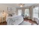 Well-lit bedroom with white-washed wood walls, a ceiling fan, and a large bed with blue decorative pillows at 120 Slate Dr, Buford, GA 30518