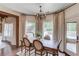 Formal dining area features large windows with custom curtains and a stylish chandelier at 120 Slate Dr, Buford, GA 30518