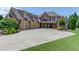 Elegant brick home featuring a three-car garage and pristine landscaping, creating a striking curb appeal at 120 Slate Dr, Buford, GA 30518