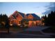Charming brick house at dusk, illuminated by warm exterior lighting, showcasing its architectural details and inviting ambiance at 120 Slate Dr, Buford, GA 30518