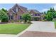 Stately brick home with manicured lawn, mature trees, and a spacious driveway leading to a welcoming entrance at 120 Slate Dr, Buford, GA 30518