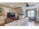 Cozy living room featuring a comfortable sofa, large TV, ceiling fan, and decorative shelving at 120 Slate Dr, Buford, GA 30518