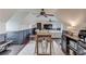 Open living area with a bar, large sofa, piano and hardwood floors under a slanted ceiling at 120 Slate Dr, Buford, GA 30518