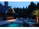 Evening shot of a cozy outdoor patio featuring comfortable seating, a fire pit, and lush landscaping at 120 Slate Dr, Buford, GA 30518