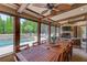 The screened-in patio offers outdoor seating with a lovely view of the pool and backyard at 120 Slate Dr, Buford, GA 30518