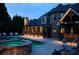 Night view of a beautifully lit pool and spa area, highlighting the home's luxurious outdoor space at 120 Slate Dr, Buford, GA 30518