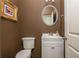 Charming powder room with white vanity, brown walls and decorative framed art at 4583 Grenadine Cir, Acworth, GA 30101