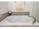 Elegant bathtub featuring modern fixtures, neutral tile, and a decorative towel arrangement at 4583 Grenadine Cir, Acworth, GA 30101