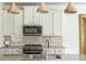 Bright kitchen features stainless steel appliances, tile backsplash and granite countertops at 4583 Grenadine Cir, Acworth, GA 30101