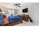 Bedroom with ceiling fan, large window, and sleek TV, complemented by stylish dressers and ample space at 46 Le Parc Fontaine, Lithonia, GA 30038