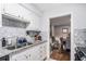 Bright kitchen features stainless steel sink, granite counters, white cabinets and stylish tile backsplash at 46 Le Parc Fontaine, Lithonia, GA 30038
